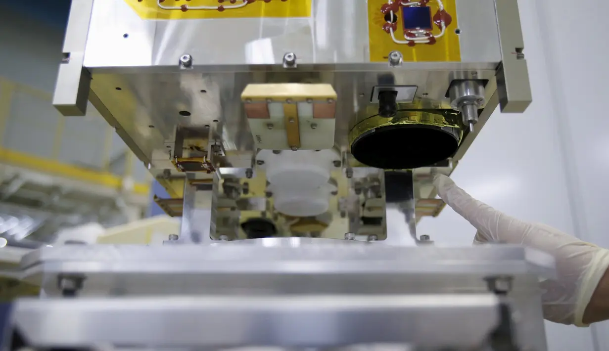 Staf dari Japan Aerospace Exploration Agency (JAXA) saat menunjuk lensa pada Diwata - 1 di JAXA Tsukuba Space Center, Jepang, (13/1). Alat ini nantinya bermanfaat bagi bidang keamanan dan penanggulangan bencana. (REUTERS / Yuya Shino)