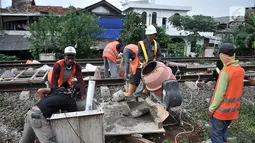 Pekerja menyelesaikan pondasi tiang sinyal elektrik jalur DDT Manggarai-Cikarang, Jakarta, Selasa (13/11). Sistem persinyalan ini seluruhnya dibangun menggunakan produk dalam negeri buatan PT Len Railway System (LRS). (Merdeka.com/Iqbal S. Nugroho)